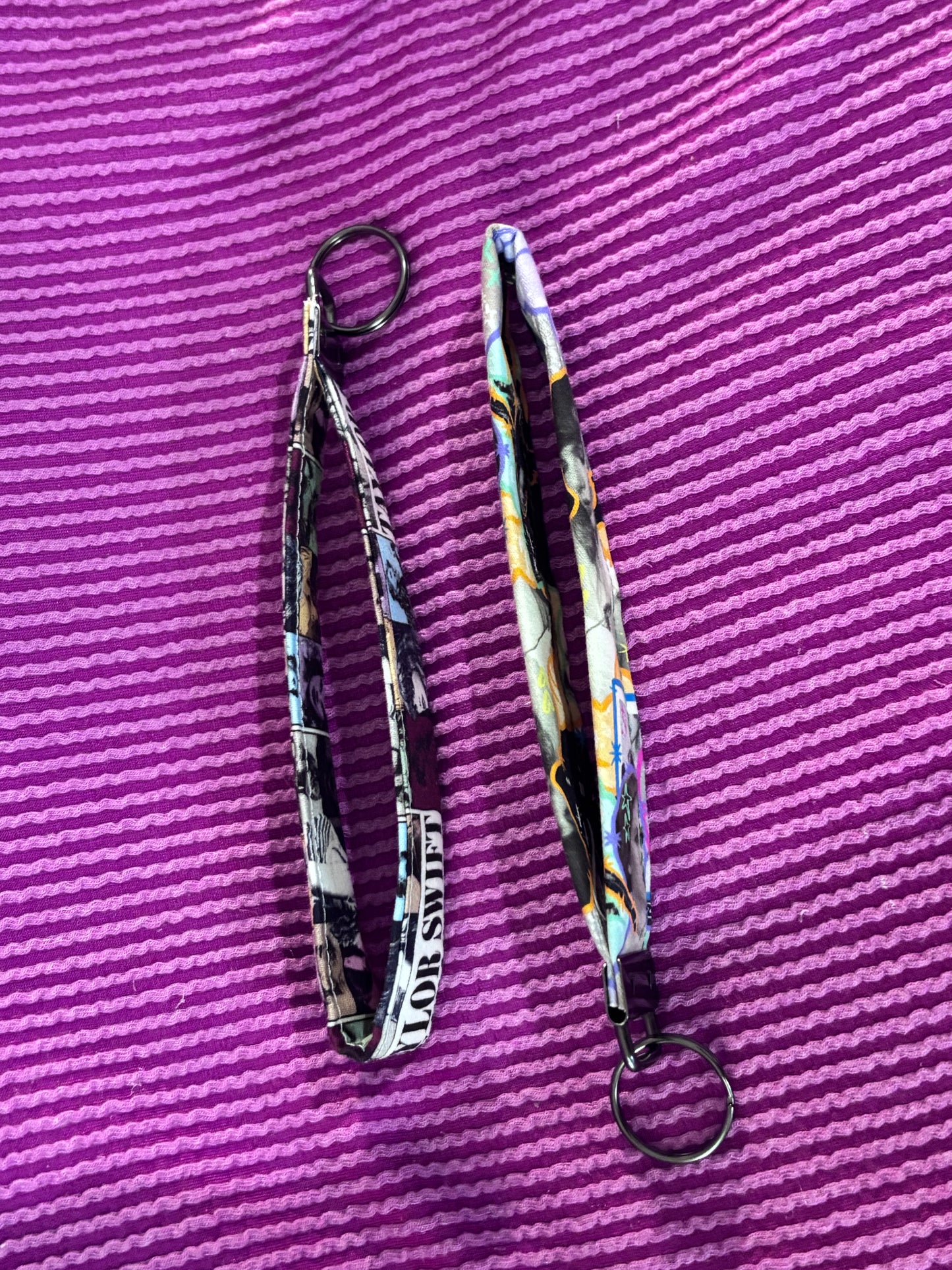 Two patterned lanyards on a purple textured surface