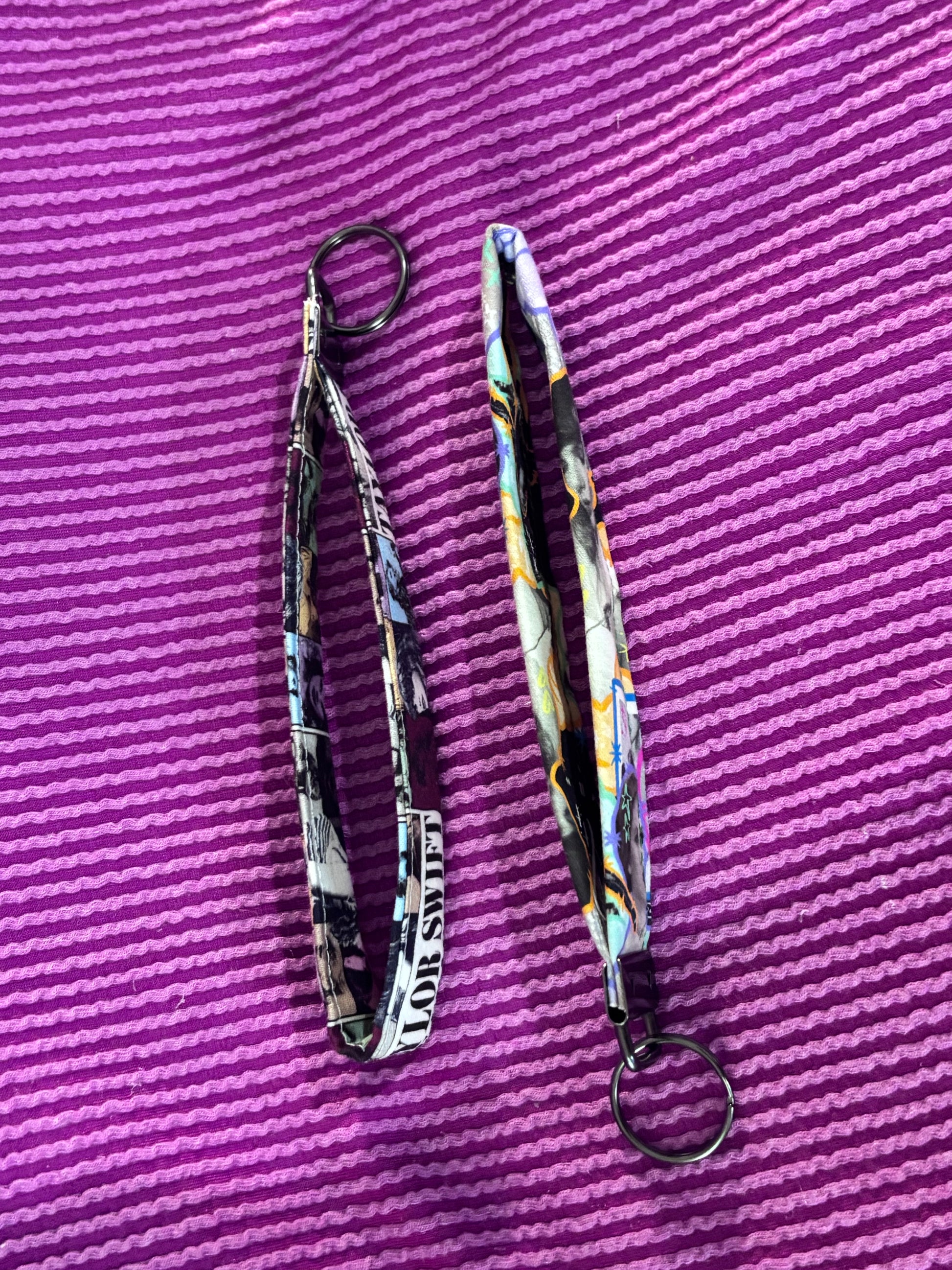 Two patterned lanyards on a purple textured surface