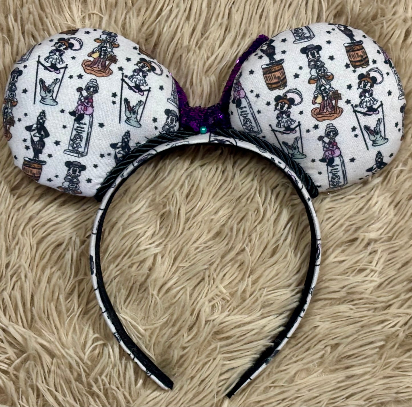 A set of ears with a fab 5 stretching room fabric on the ears front and back along with the headband as well. Black twisted trim along the inner ears with a purple sequin bow. Back view of ears.