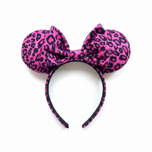 Pink leopard print headband with bow on a white background