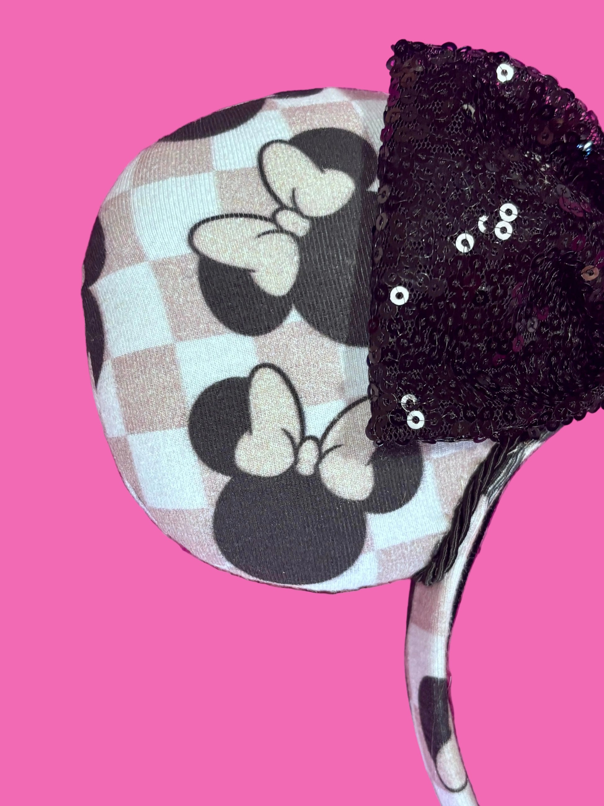 close up of front mouse ear. Handmade and ready to ship Checkered Mouse ears with famous Minnie ear bows on the design and a black sequin bow with black twisted trim on a universal sized headband.