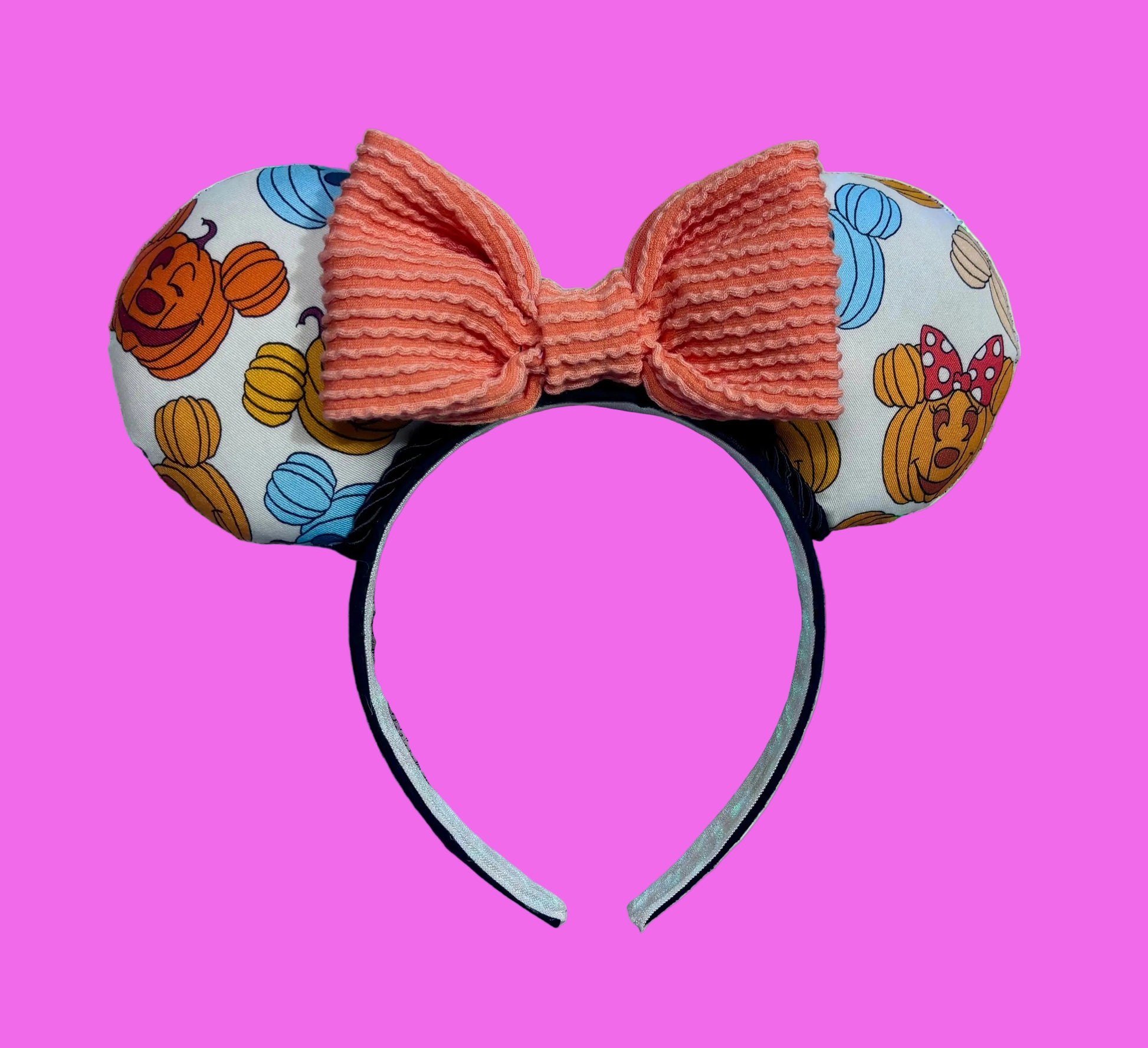 Handmade and ready to ship mouse pumpkin custom ears with pumpkins on the front and back pf ears. Black twisted trim is along the inner ears with an orange waffle print bow on a black universal sized headband. 