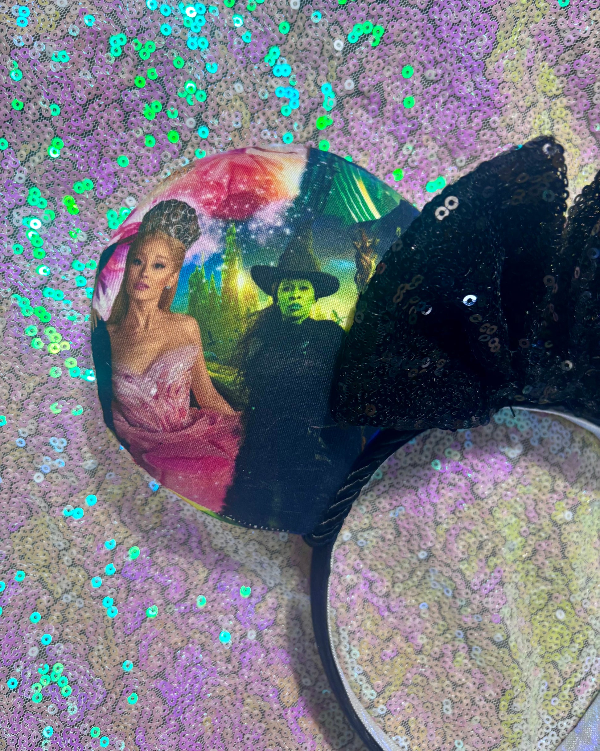 Black sequin bow with a colorful character design on a glittery background