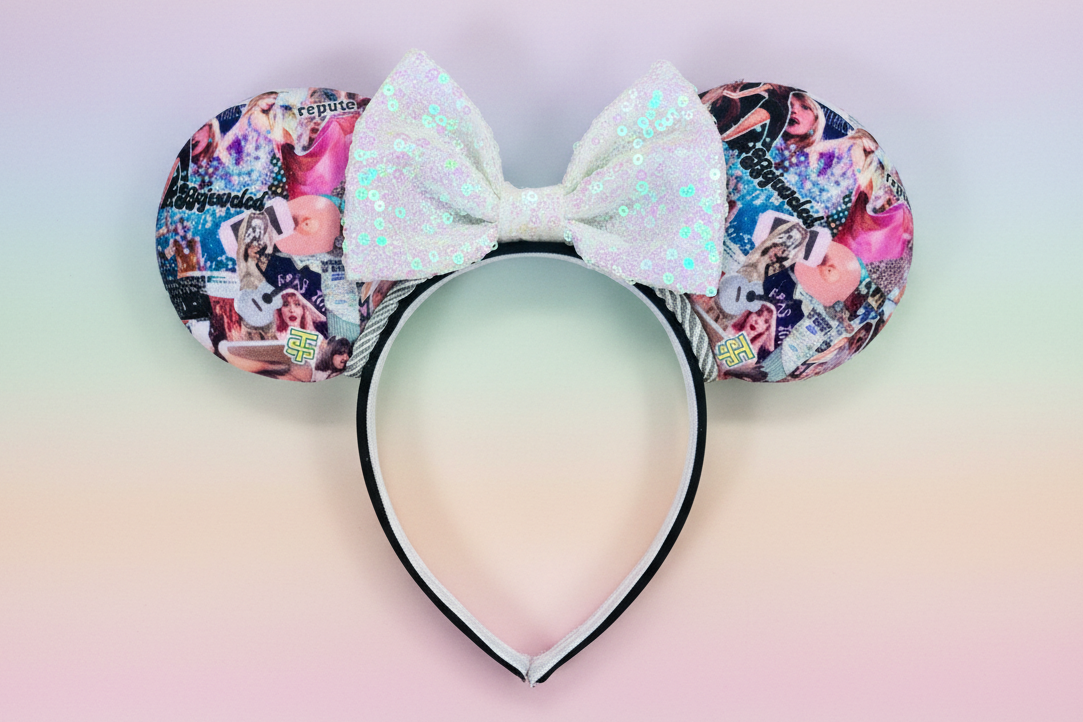 Colorful swiftie collage fabric Minnie Mouse ears with a white sequin bow and silver twisted trim. Shown on a gradient background