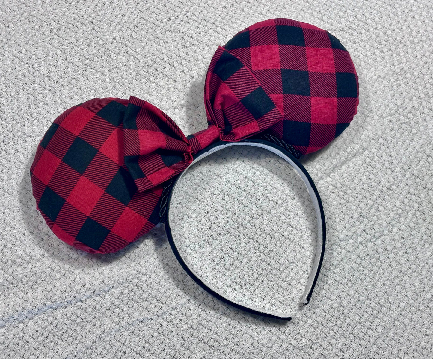 Handmade and ready to ship Buffalo Plaid mouse ears on both the front and back. On a black headband that is universal sized. The set has a matching buffalo plaid bow. Item is shown on a white background.