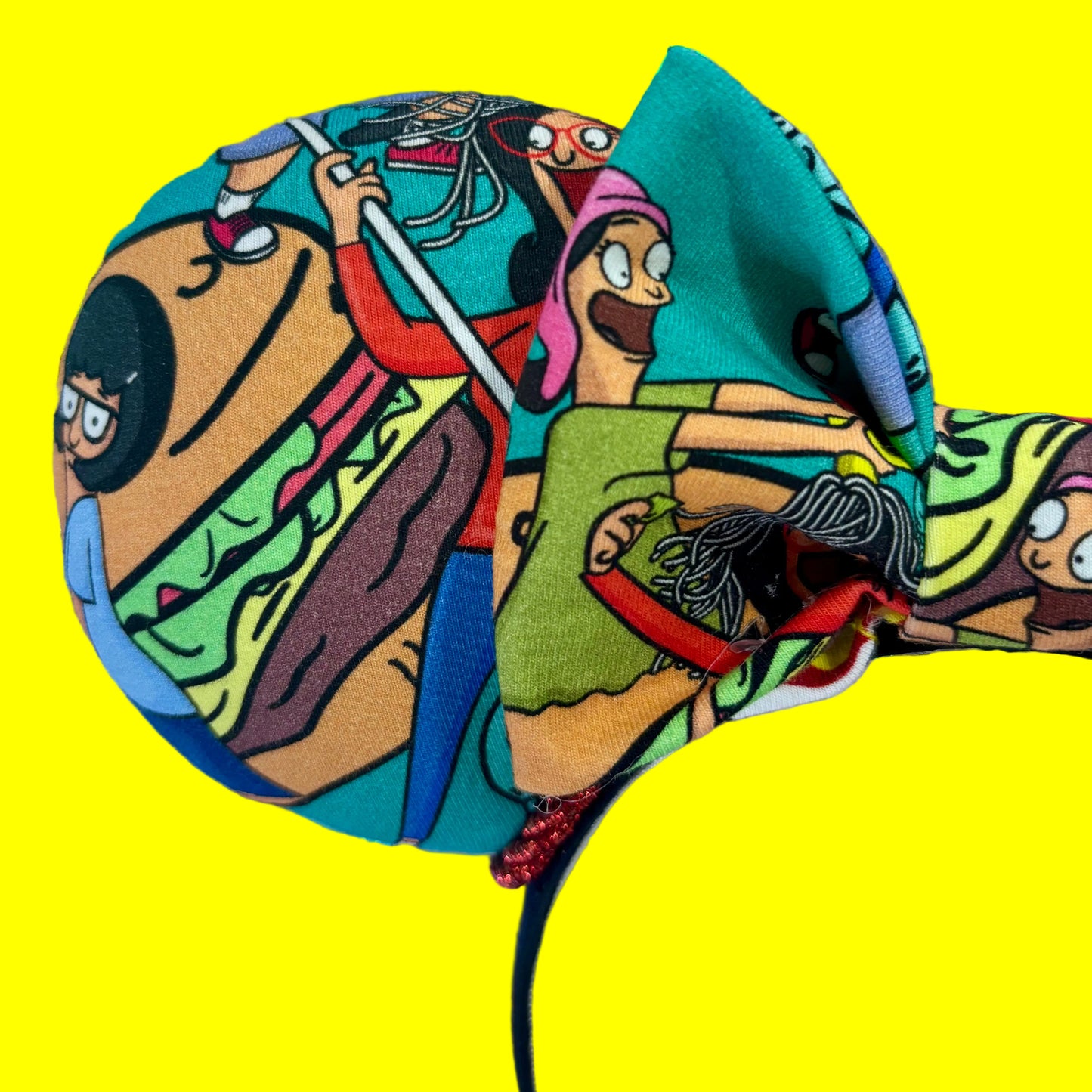 Close up of front mouse ear showing a burger a characters from the show.