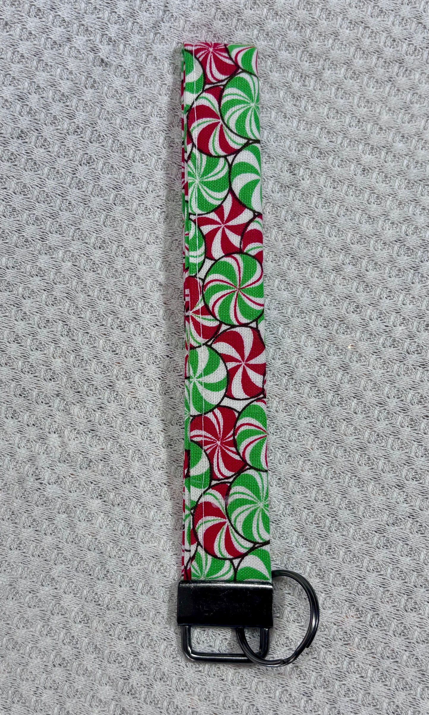 Keychain wristlet with candy cane pattern on a textured gray background