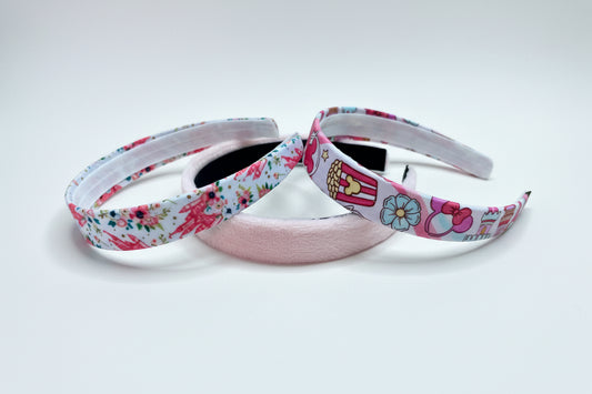 Three handmade and ready to ship headbands with floral castles, plush pink and MK cartoon designs on universal sized headbands.