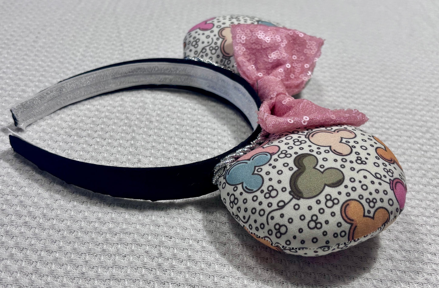 Side view of Handmade and ready to ship Mouse ears mouse balloons with a light pink sequin bow. Perfect for Main Street. Shown on a gold white background.