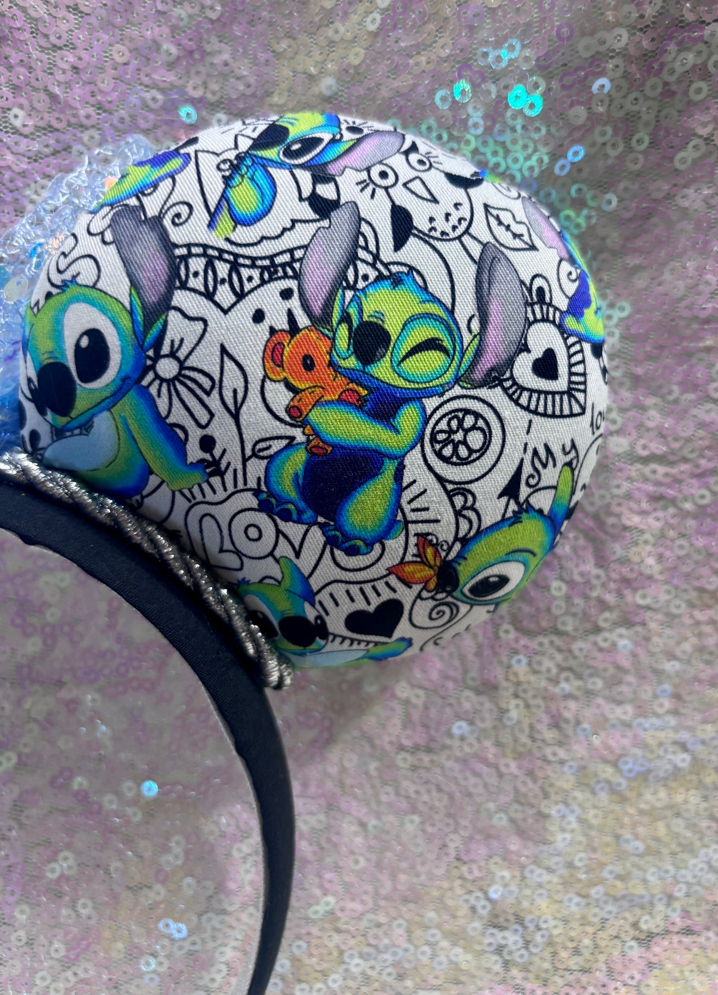 Handmade and ready to ship Mouse ears with Stitch cartoon character design and a blue sequin bow. Close up of back right ear.