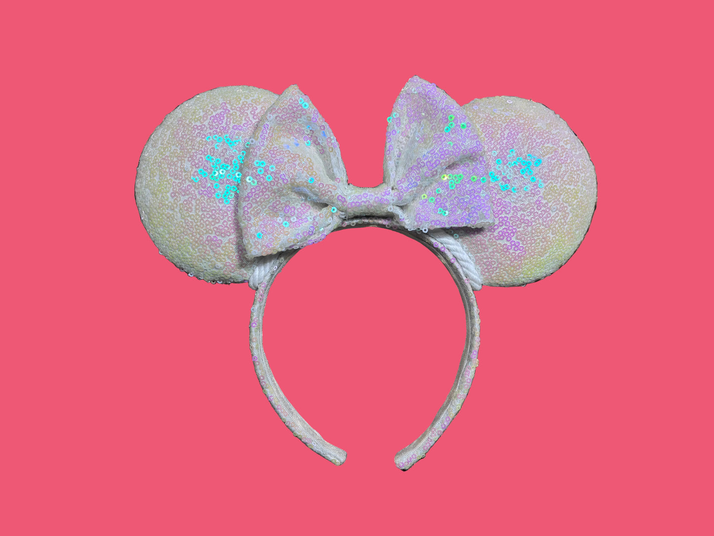 White Iridescent mouse ears with the fabric on both the front and back. The fabric is on the headband as well and is universal sized and fits most. The set has a matching iridescent sequin bow. 