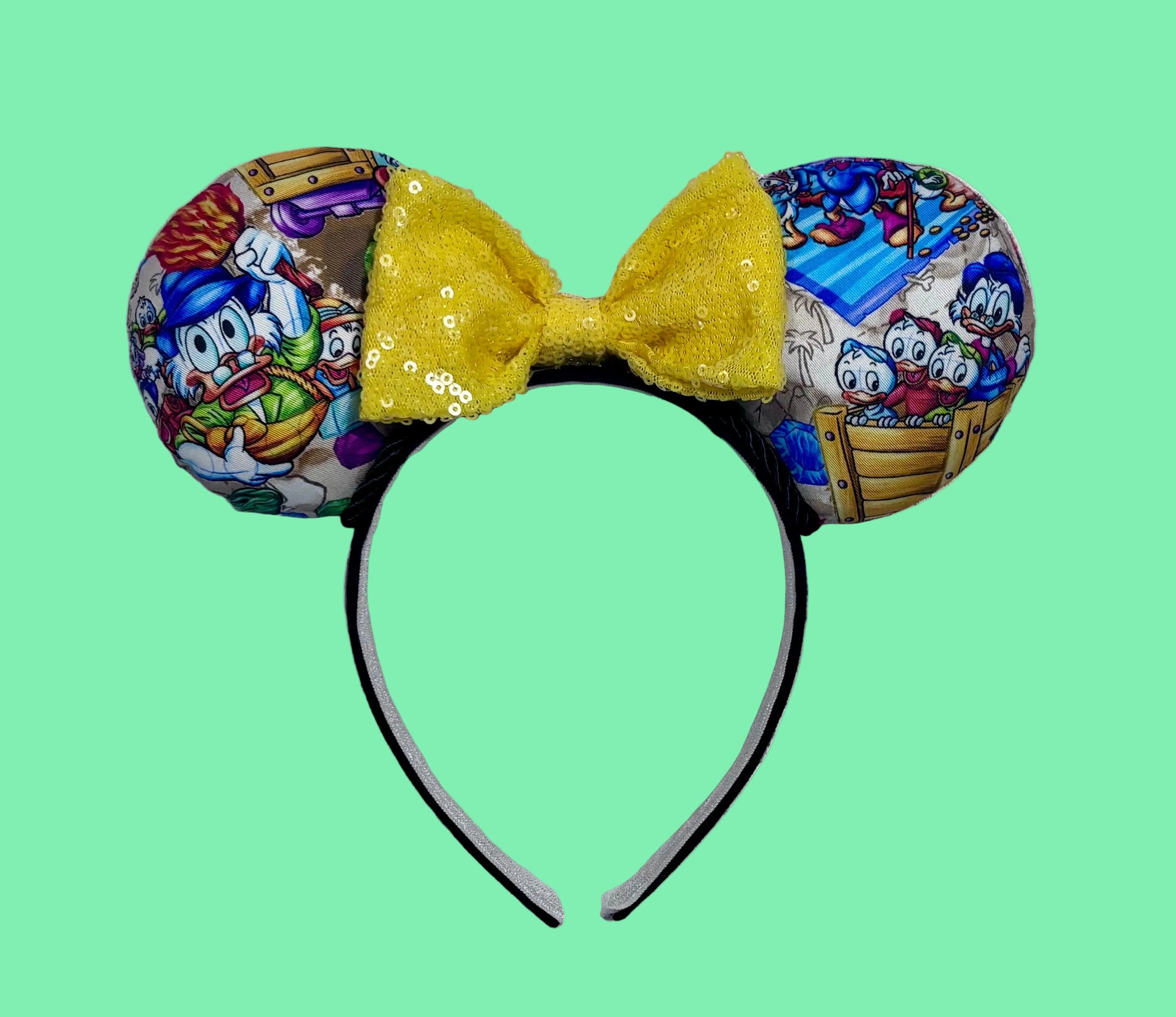 Handmade and ready to ship Colorful mouse ears with DuckTales Inspired fabric on the ears front and back with a Yellow Sequin bow on a universal sized black poly cotton fabric headband.