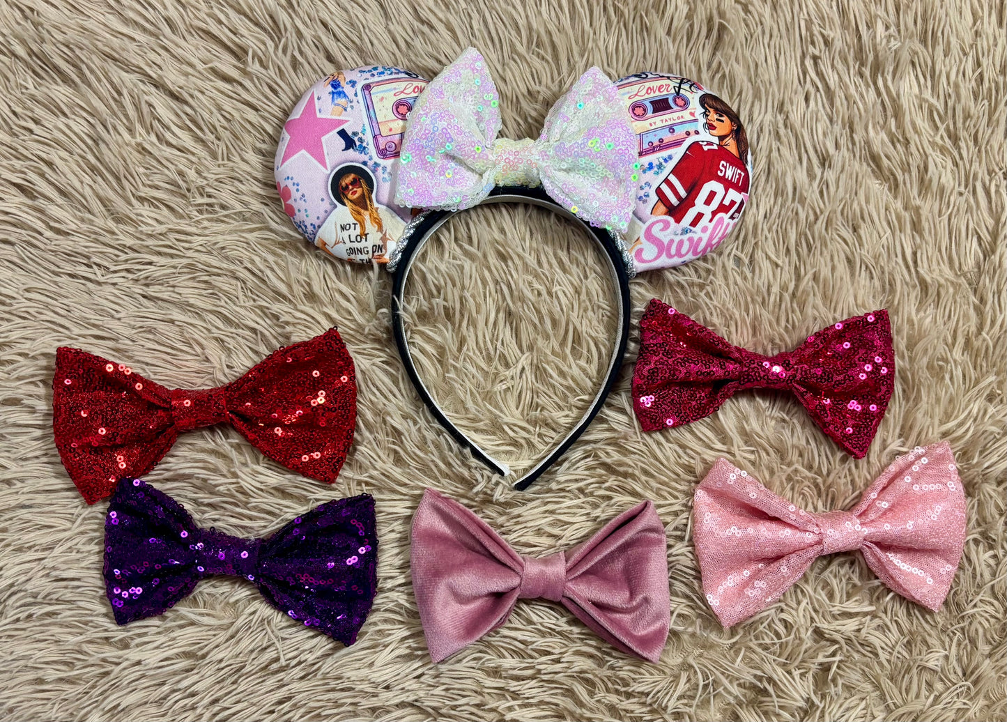 An ear headband with a large iridescent bow and custom printed ears featuring retro cassette graphics, a pink star, and a portrait of singer. Shown with bow color options in case you don't want the white iridescent one. 