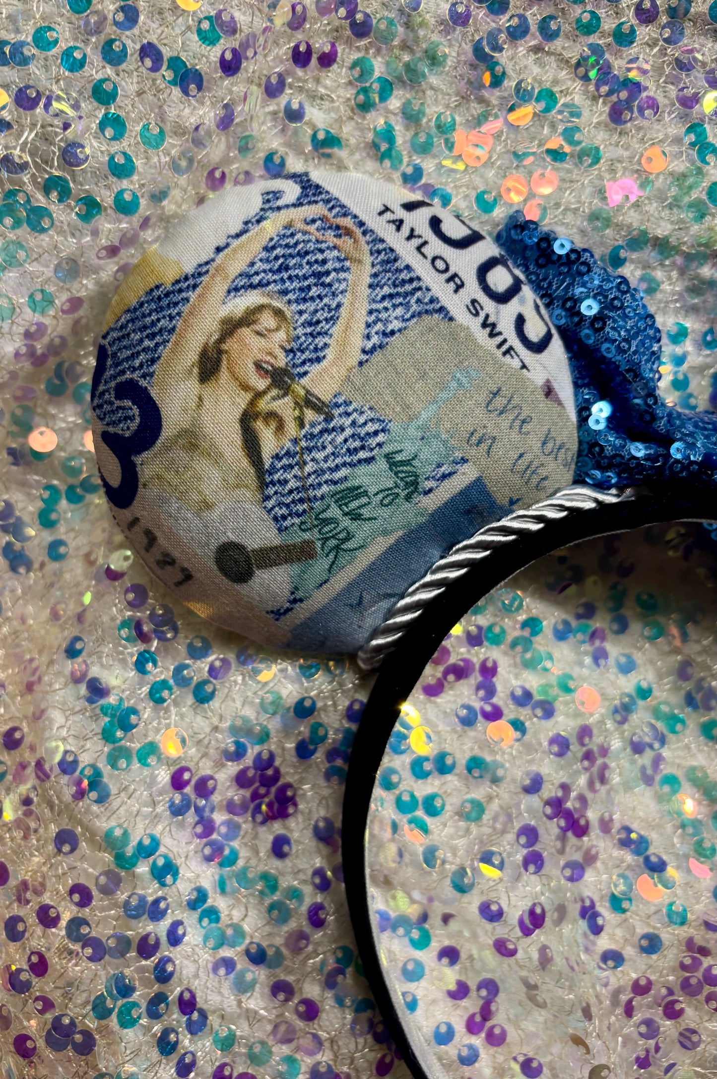 Handmade and ready to ship. Close up of the back left custom ear with a design of TS singing and playing guitar on tour.