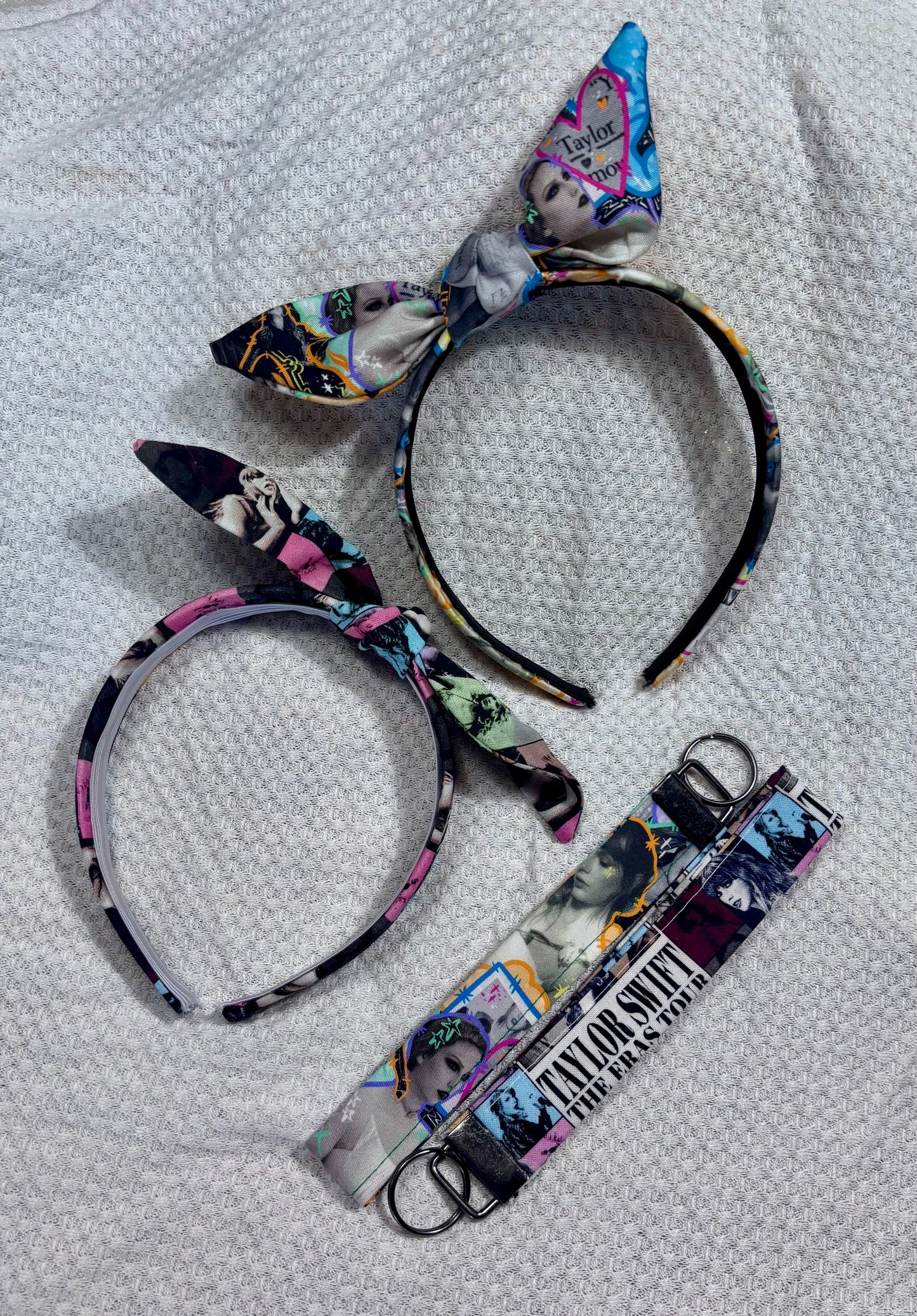 Two headbands with decorative bows and two matching lanyards on a textured white background