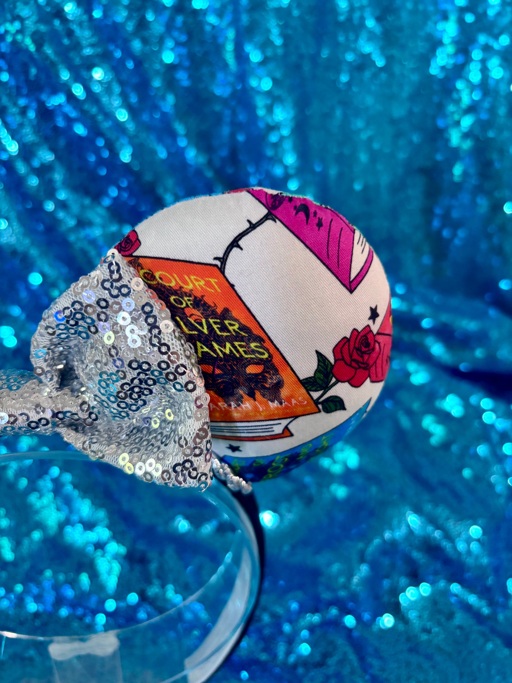 The other front side view of the mouse ears with books, a rose and showing the bow and headband.