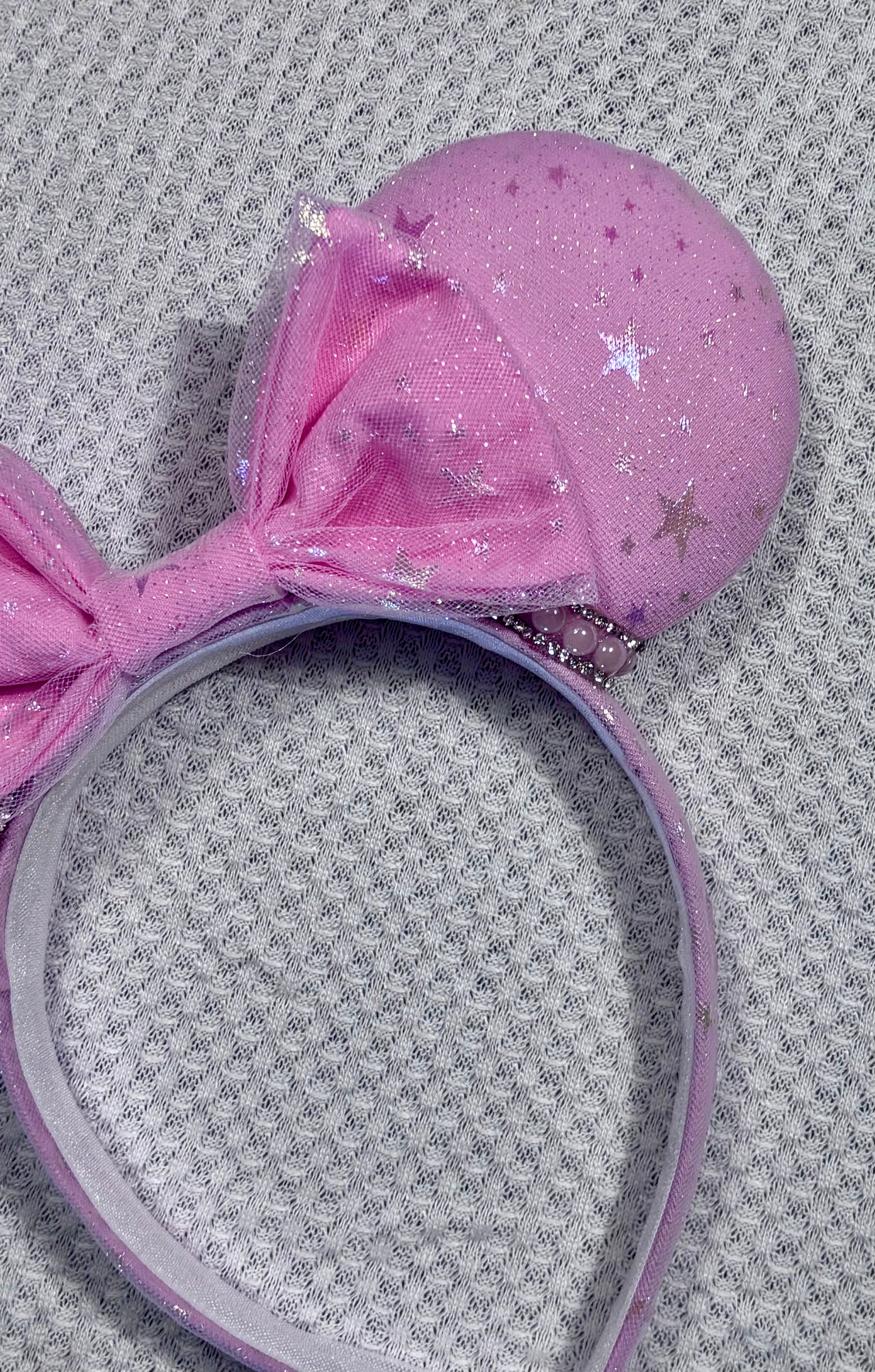 Handmade and ready to ship Pink Sparkling Iridescent fabric on pink to make mouse ears with the fabric on both the front and back along with the headband the is universal sized and fits most. The set has a matching bow, but you can request any sequin color in your order and I'll attach it. Item is shown on a white background.