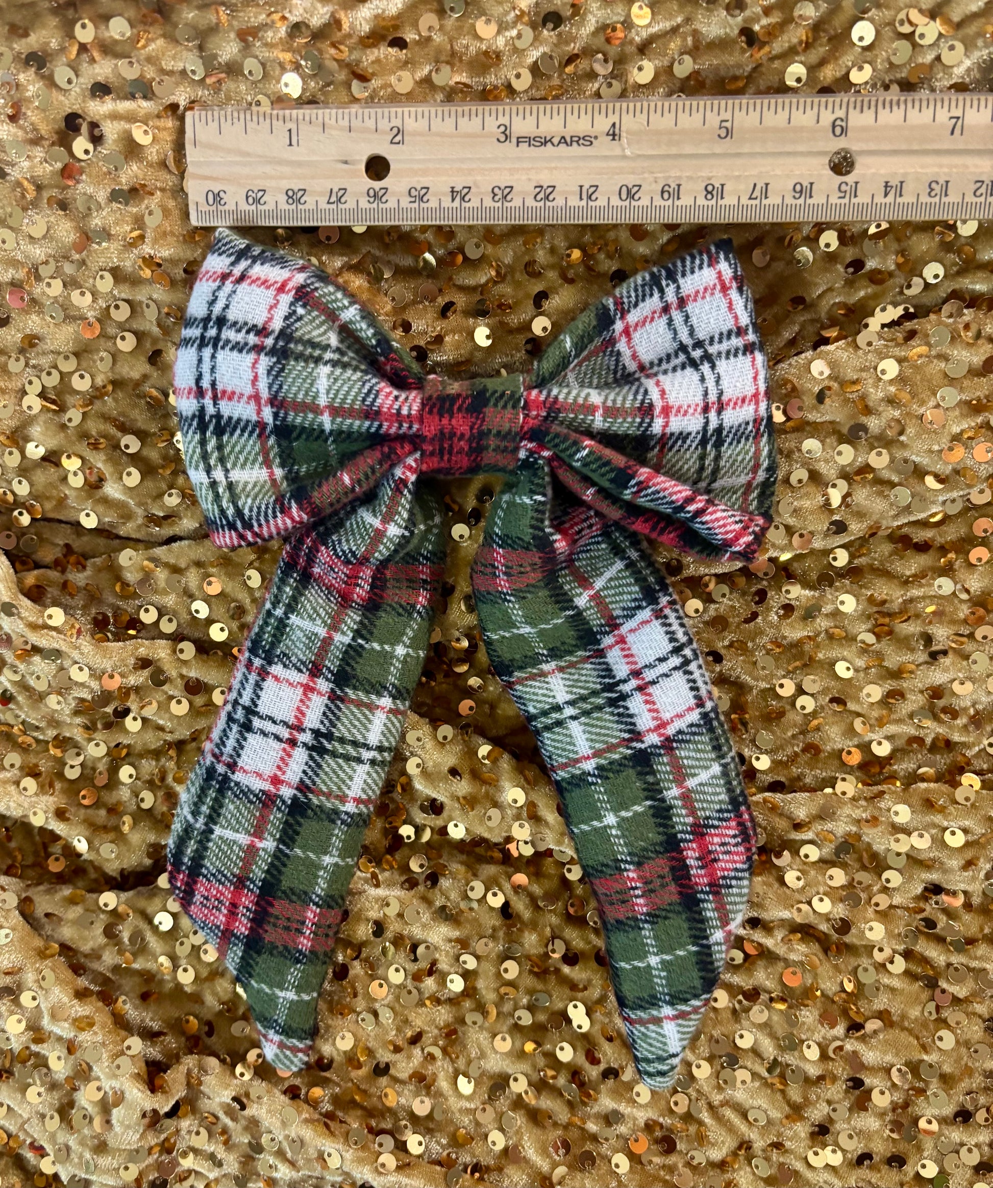 Plaid bow with a ruler on a gold sequin background