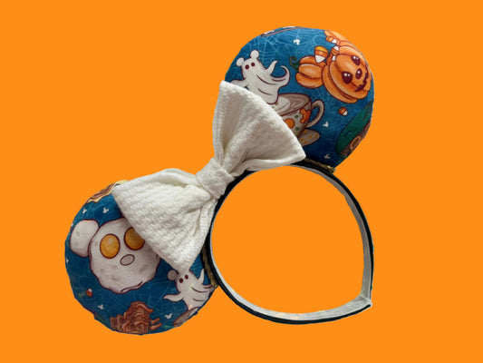 Handmade and ready to ship Fall Mouse ears with pumpkins, eggs, waffles and more shaped like mouse ears is on the front and back of mouse ears with a white waffle print bow.
