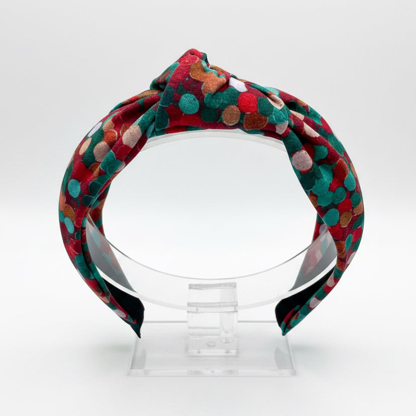 Christmas colors headband on a clear stand with a white background. Handmade and ready to ship.