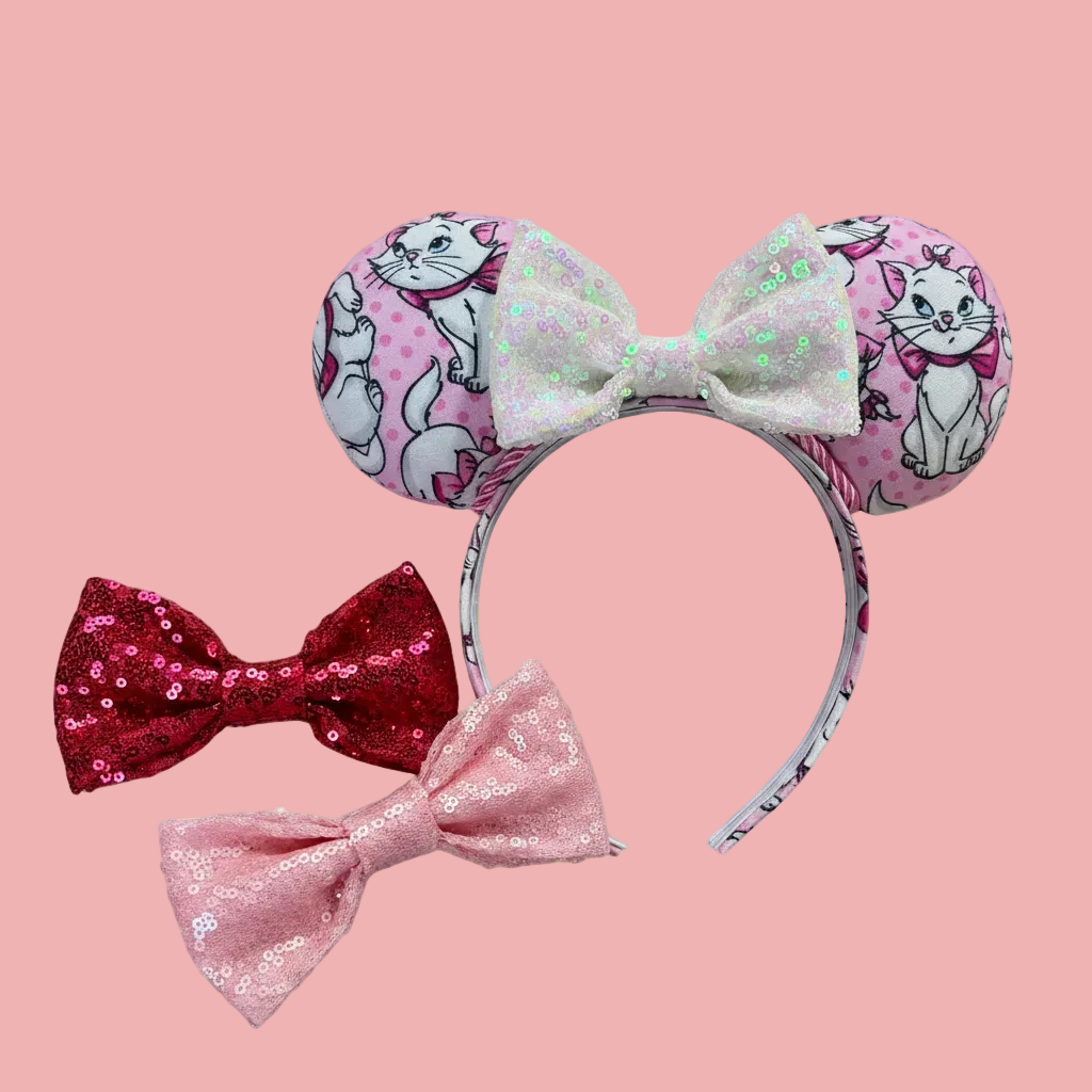 Handmade and ready to ship Marie Inspired Mouse ears with images of her on the front and back of mouse ears shown with a white iridescent sequin bow. The headband has a matching Marie poly cotton fabric and is a universal sized headband. Shown with other bow colors in hot pink and light pink if you want a different color attached. 