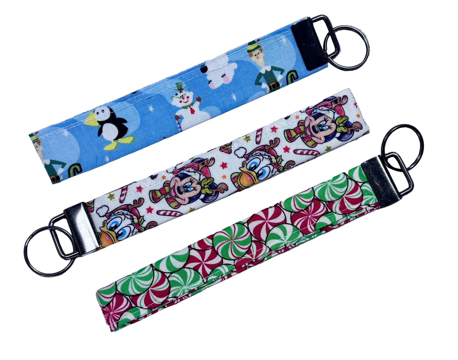 Three colorful keychains with different designs on a textured gray surface.