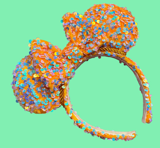 Sequined bow headband on a colorful fabric background