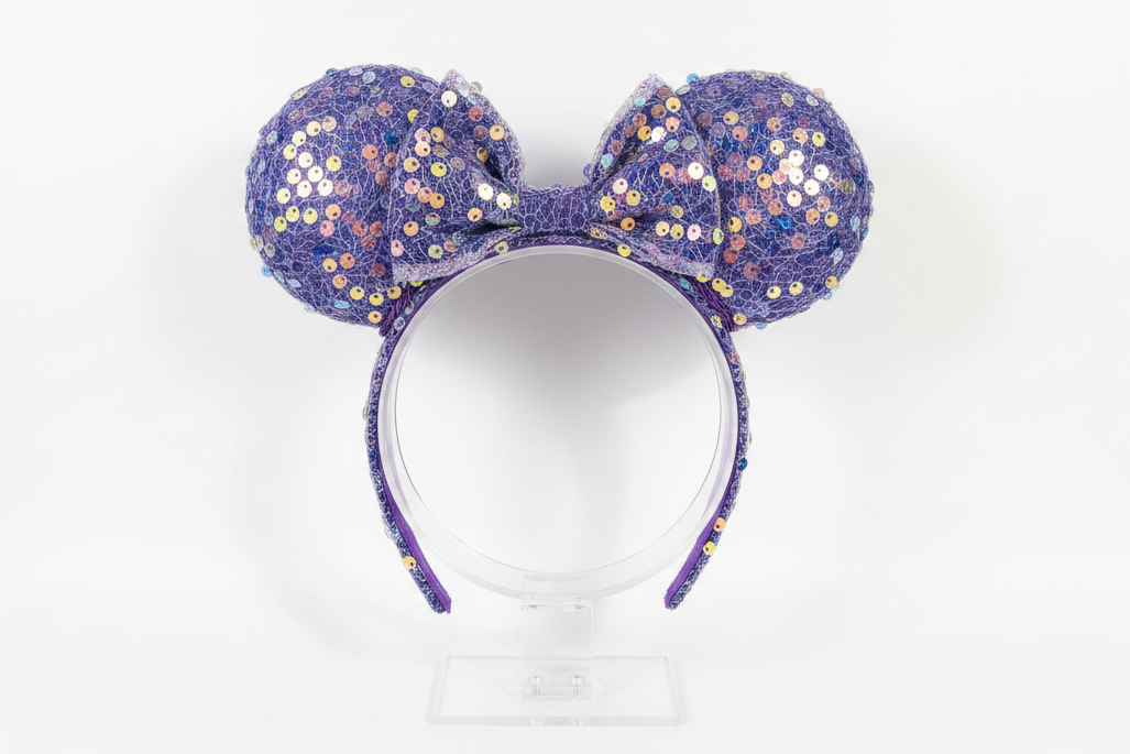 Purple sequin mouse ears on a white background