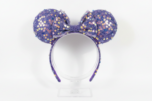 Purple sequin mouse ears on a white background