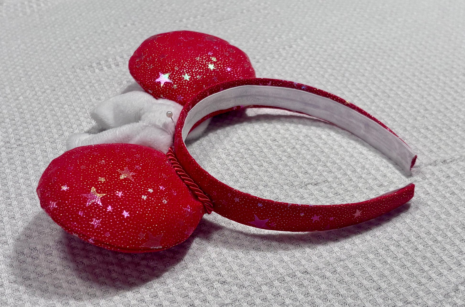 Red glittery headband with star decorations on a textured gray background. Bow is only pinned and not attached until you order. If you would prefer a different bow, I have most colors in sequins. Just write a note in your order and I will attach your preference. 