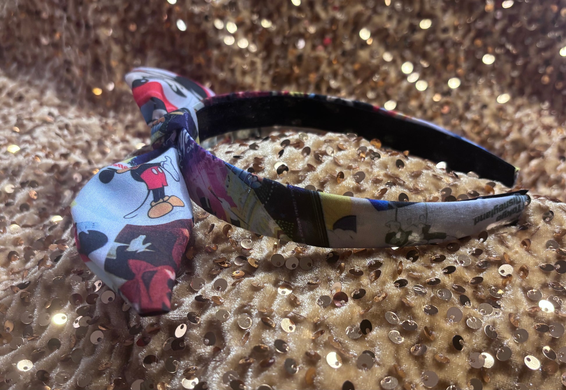 Side view of Park themed twisted headband showing views of Mickey and friends.
