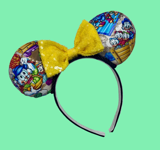 Handmade and ready to ship Colorful mouse ears with DuckTales Inspired fabric on the ears front and back with a Yellow Sequin bow on a universal sized black poly cotton fabric headband.
