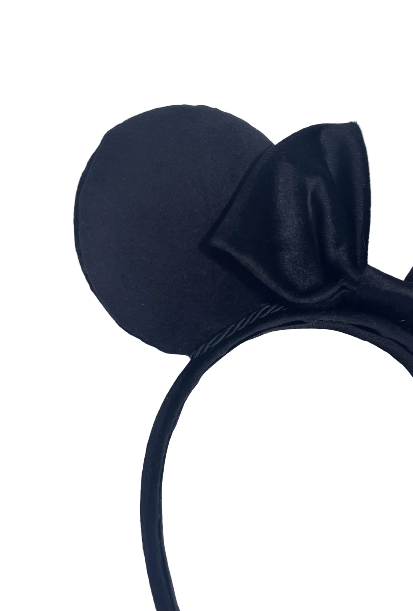 black velvet headband with a bow on a textured gray background