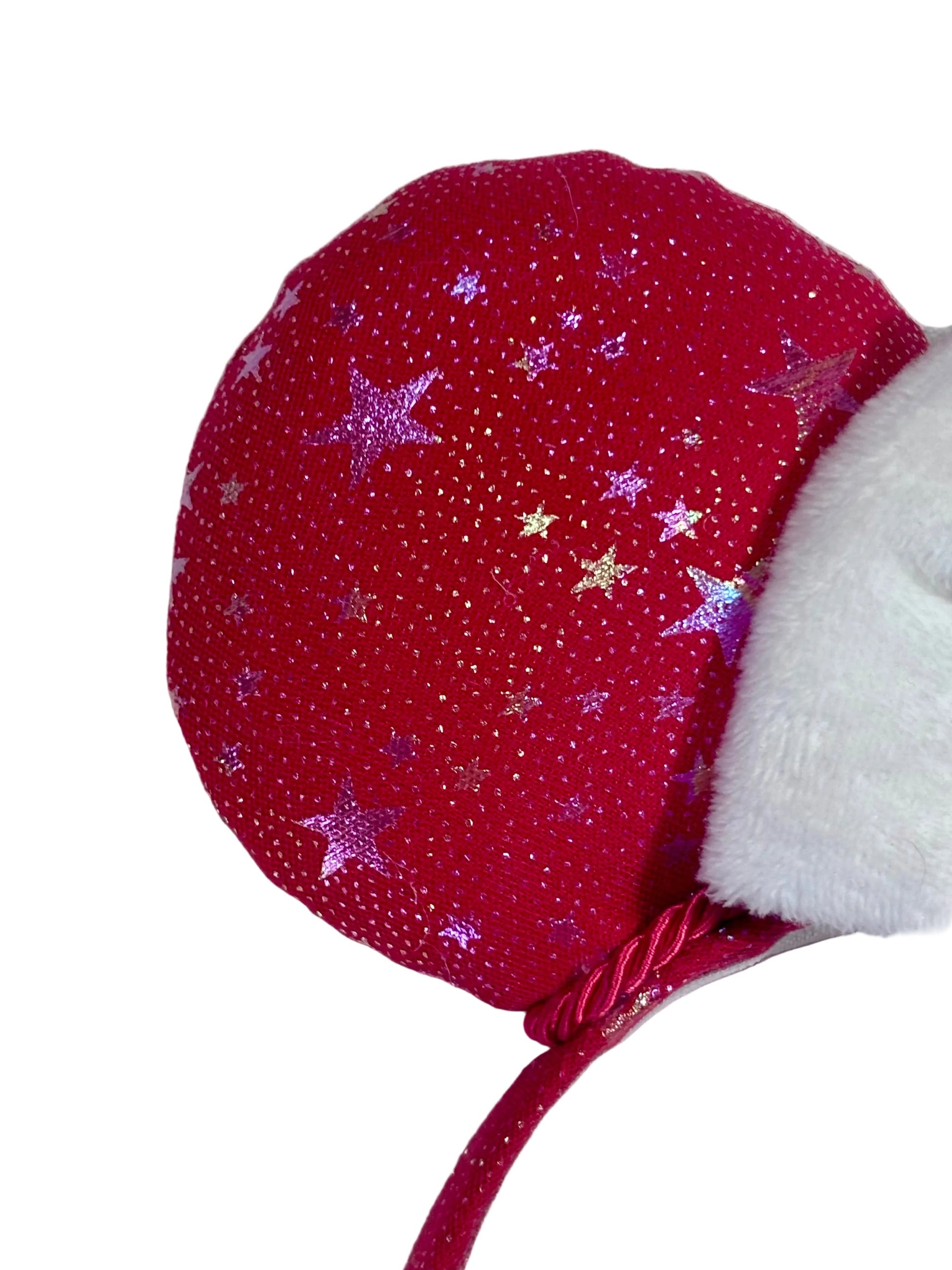 Handmade and ready to ship red mouse ears with iridescent stars on both the front and back along with the headband as well. The set has a white soft bow. Item is shown on a white background.