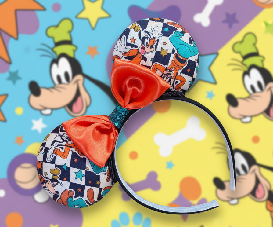 Colorful mouse ears with Goofy cartoon character with checkered print on it and an orange satin bow with turquoise middle. design is shown on a multicolored background