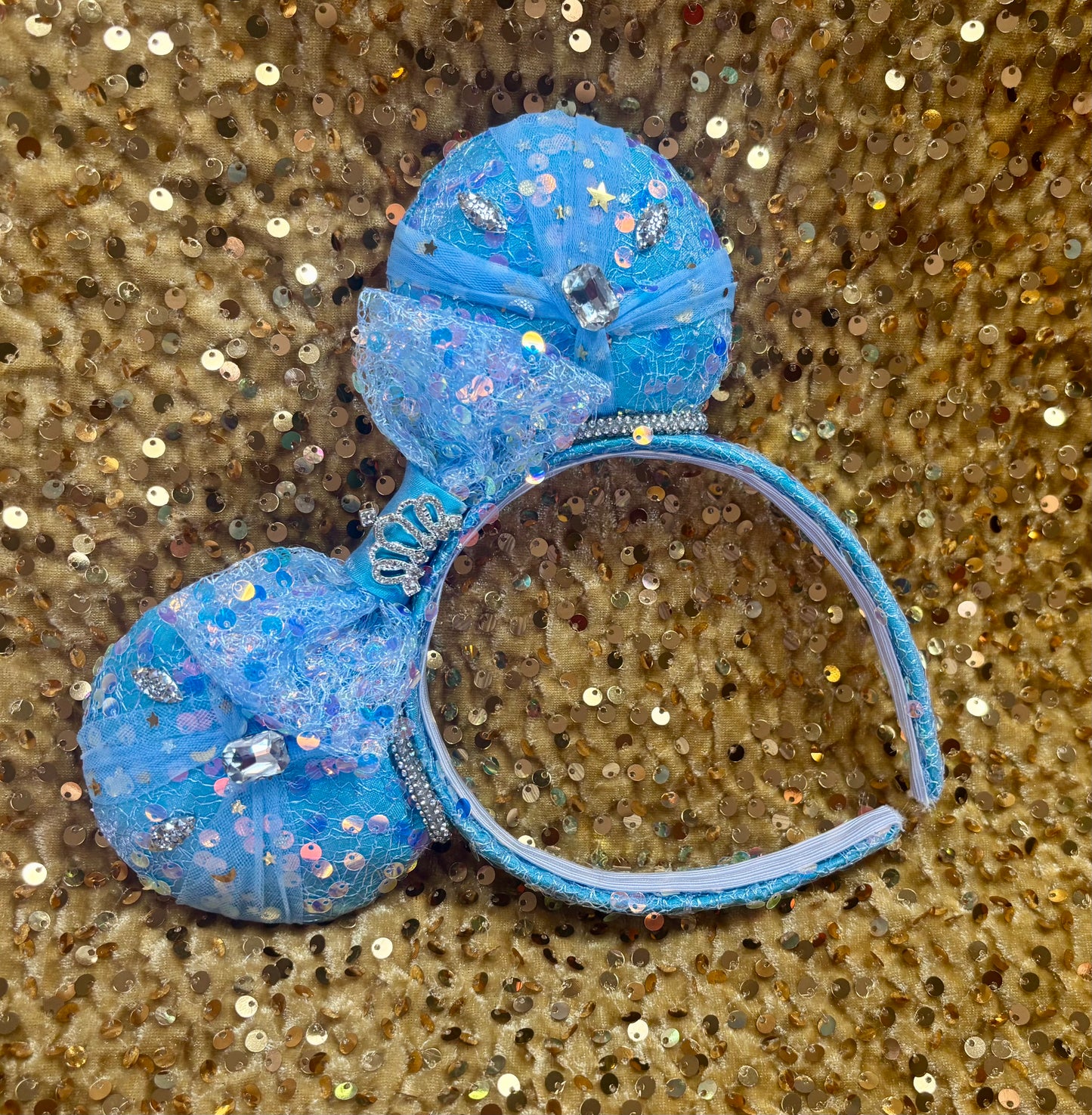 Handmade and ready to ship blue sequin mouse ears headband inspired by Cinderella with tulle and silver gemstones with a crown charm middle and rhinestone trim along inner ears.