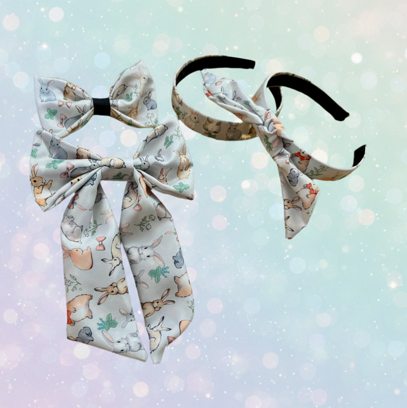 Two headbands one with a knotted bow and one without. Two bunny boys, one is regular and one is a sailor bow. All in bunny prints for Easter. Shown on a light blue background