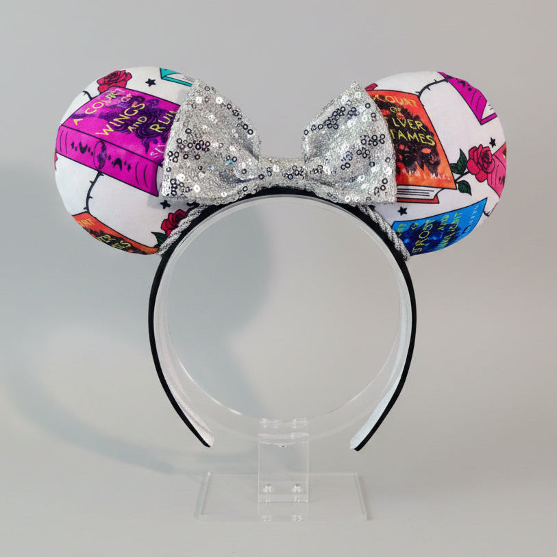 Handmade and ready to ship custom and unique ears that have images from the books on the mouse ears front and back. Silver twisted trim is along the inner ears with a silver sequin bow on a black poly cotton universal sized headband.