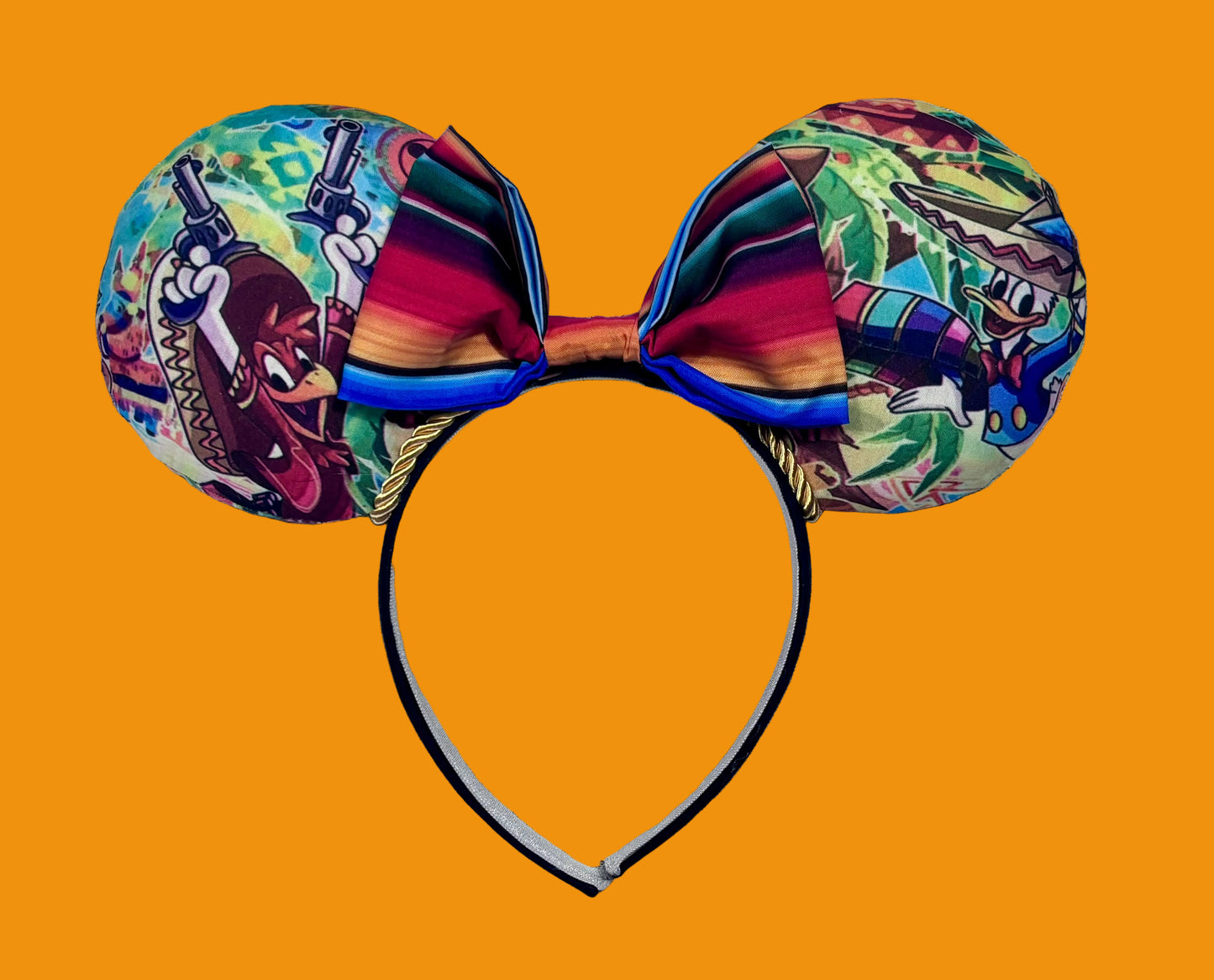 Colorful Handmade and ready to ship mouse ears with a colorful bow on an orange background with duck cartoon images on the ears front and back with Handmade and ready to ship. yellow twisted trim and on a black poly universal sized headband