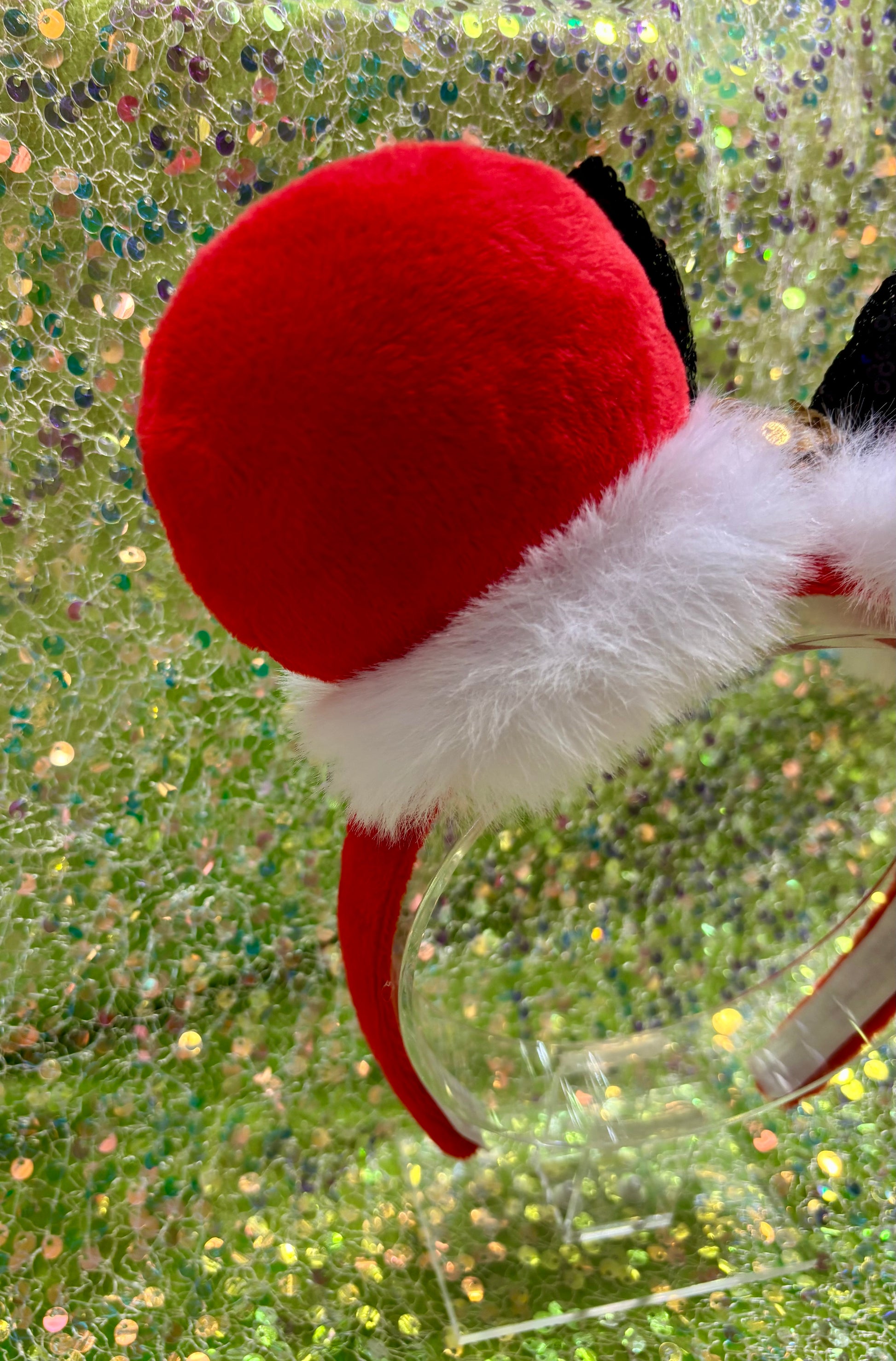 Red and white festive mouse ears with a green glittery background