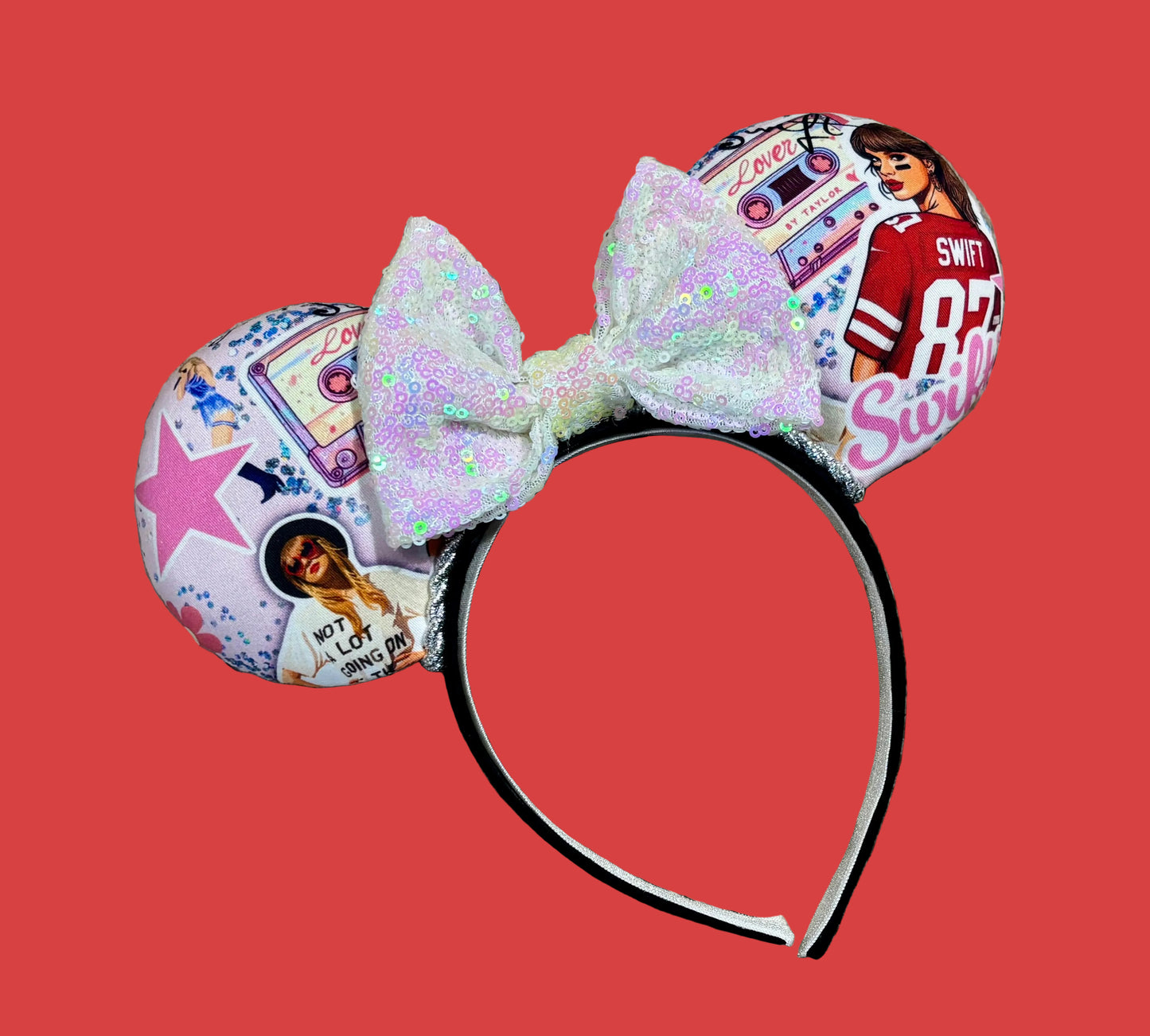 An ear headband with a large iridescent bow and custom printed ears featuring retro cassette graphics, a pink star, and a portrait of singer.