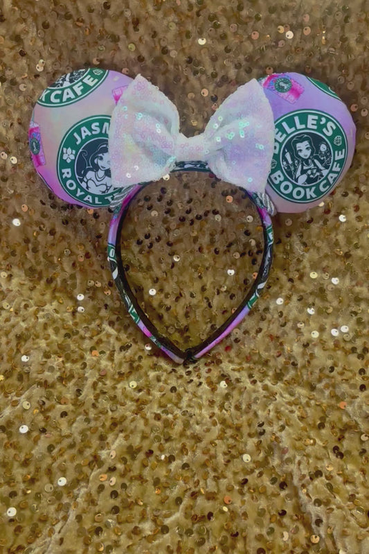 Handmade and ready to ship custom ears with popular coffee themed with princesses on fabric. White iridescent bow and silver twisted trim on a universal sized headband with matching design as the mouse ears.