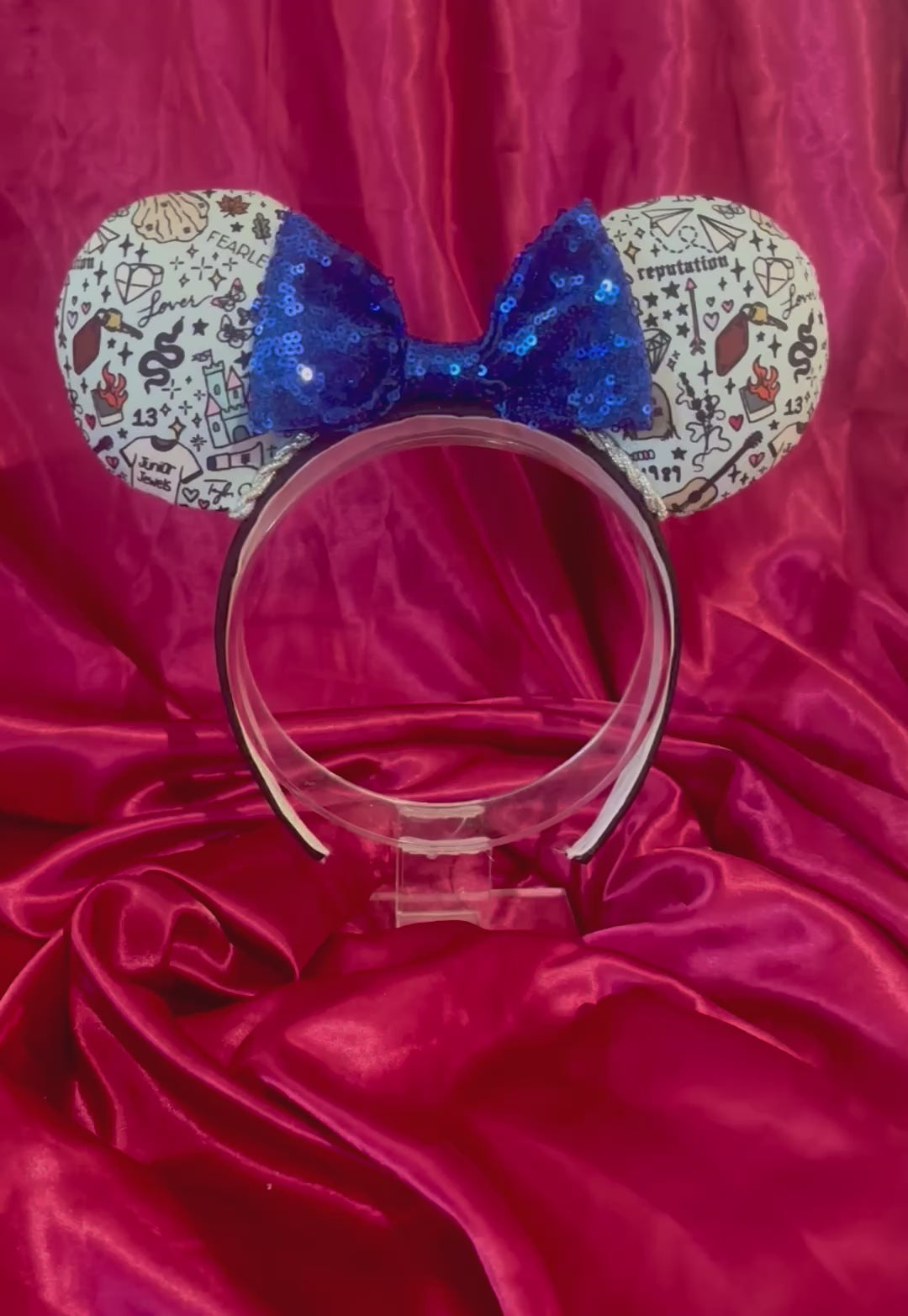 Handmade and ready to ship Tay Doodles mouse ears with drawings and titles of albums on fabric on a black universal headband, with silver trim and a blue sequin bow.