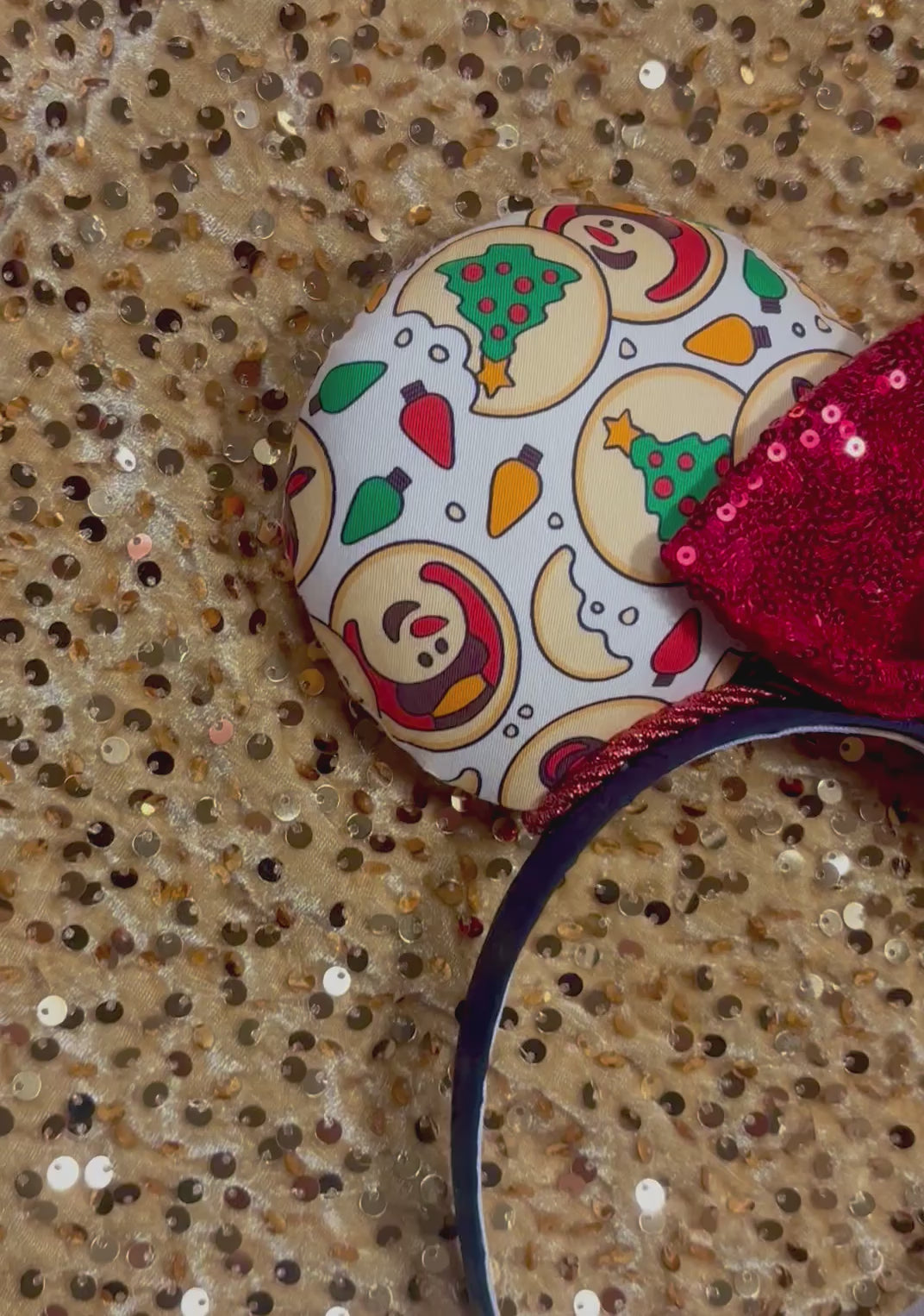 Christmas Sugar Cookie mouse ears with the fabric on both the front and back. The headband is black universal sized and fits most. The set has a red sequin bow. Item is shown on a gold sequin background.