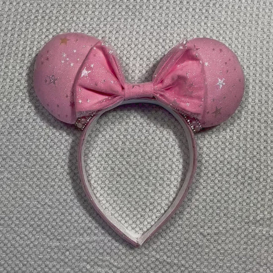 Handmade and ready to ship Pink Sparkling Iridescent fabric on pink to make mouse ears with the fabric on both the front and back along with the headband the is universal sized and fits most. The set has a matching bow, but you can request any sequin color in your order and I'll attach it. Item is shown on a white background.