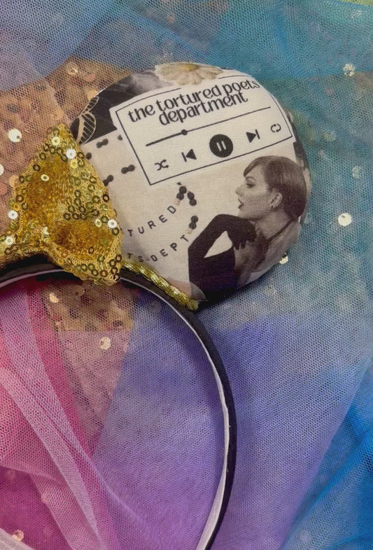 Handmade and ready to ship TTPD themed Mouse ears with collage images from that era are shown with a gold sequin bow on a headband. Shown against a glitter background.