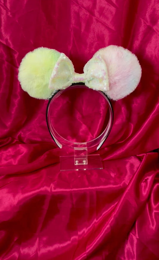 Mouse ears with a rose gold pleather bow and decorative elements on a textured satin background