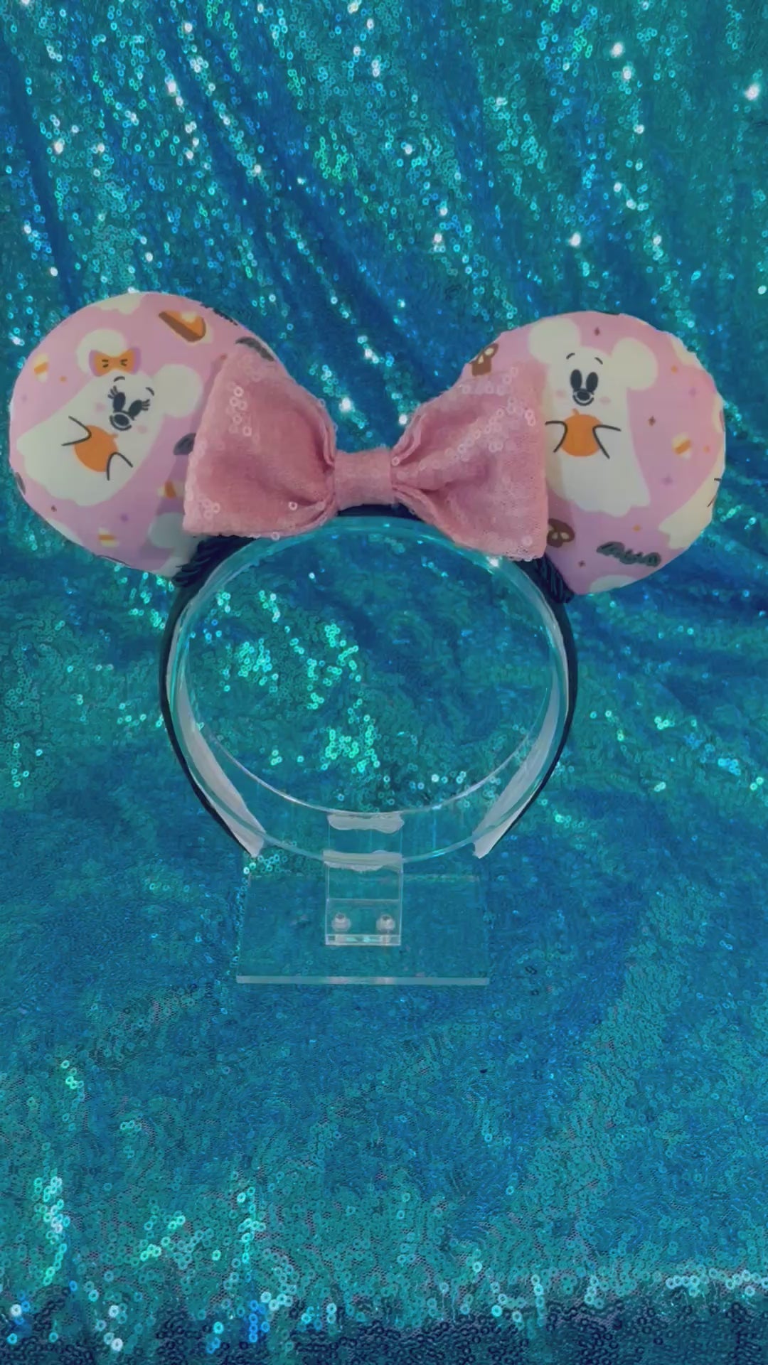 Handmade and ready to ship Halloween Pink Ghosts Mouse ears with the fabric with mouse shaped ghosts on pink fabric is on the ears, front and back and a light pink sequin bow. The headband is a universal sized headband and has black poly cotton fabric on it.
