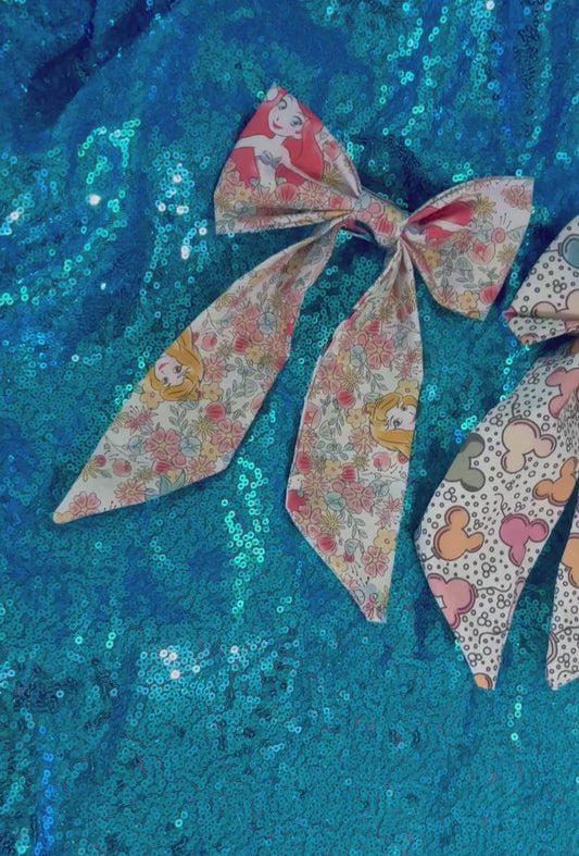 Handmade and ready to ship. Two French tailed hairbows come in this bundle in: Pretty Princess and Mouse Balloon fabric. French barrette backings are on the bow's backs.