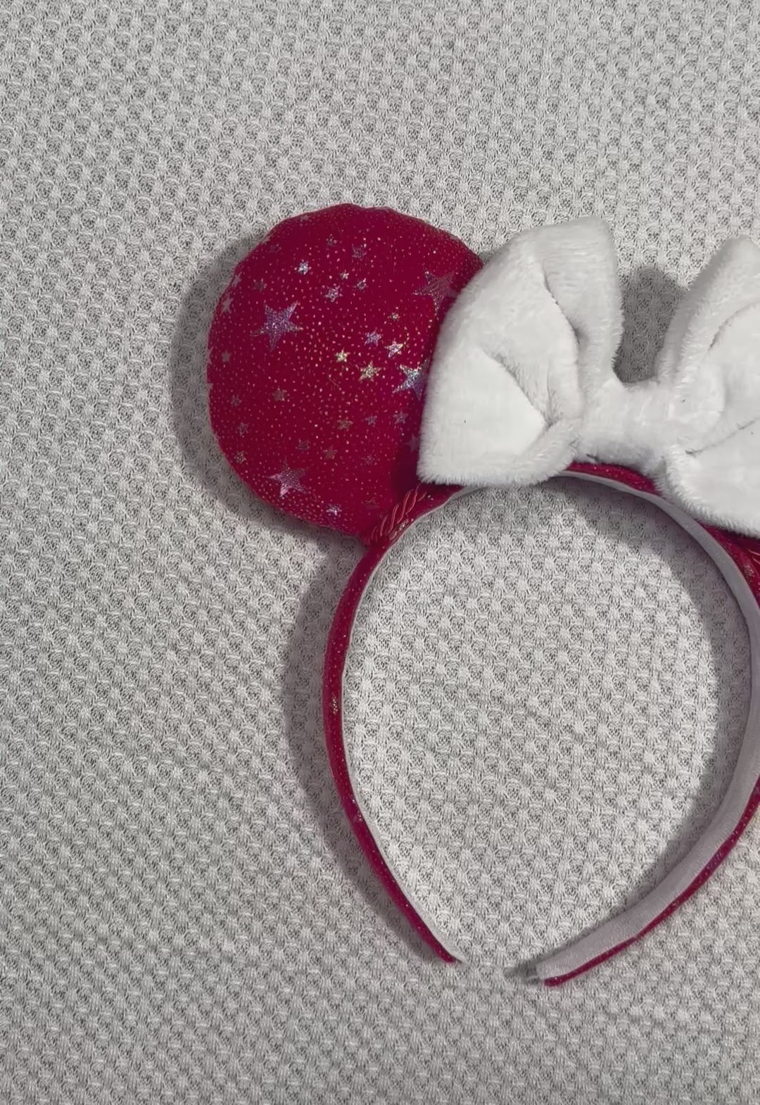 Handmade and ready to ship red mouse ears with iridescent stars on both the front and back along with the headband as well. The set has a white soft bow. Item is shown on a white background.